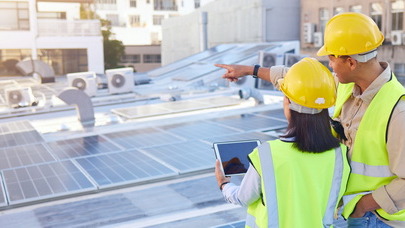 Workers on sustainable energy project on rooftop of building